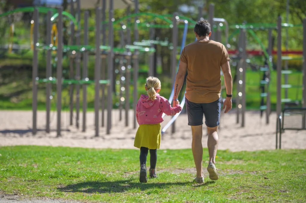 Barn och pappa i lekpark